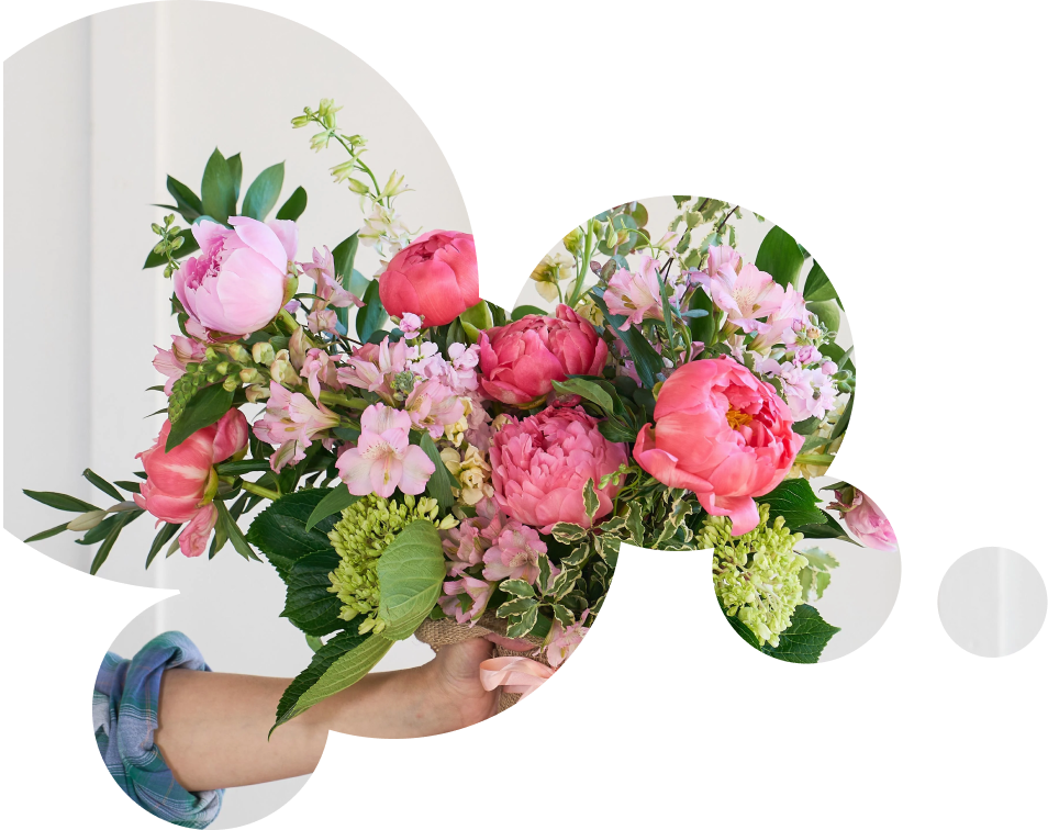 A photo of a hand holding a bouquet of pink flowers.