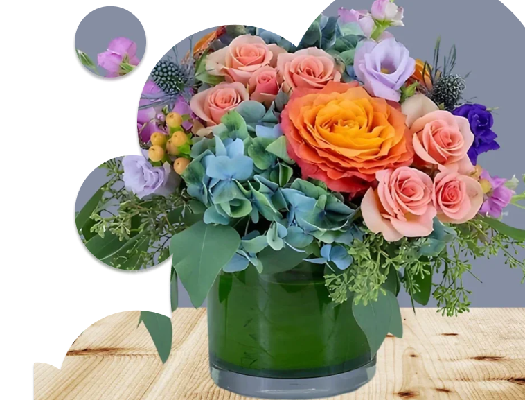 A photo of a bouquet of bright colorful flowers in a round cylindrical vase.